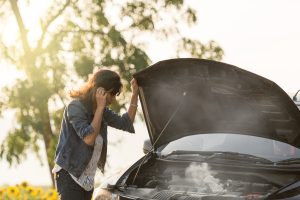 Person checking on an engine problem with their car near Anderson, IN