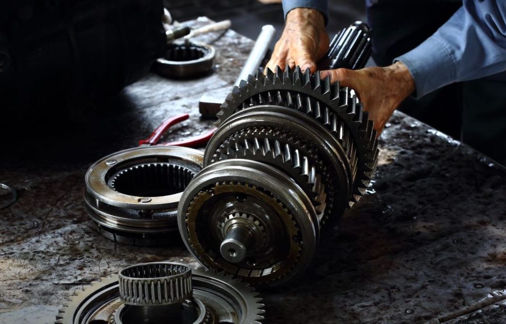 A person repariing a car transmission near Anderson, Indiana