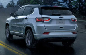 2024 Jeep Compass driving down a road in the rain near Anderson, Indiana.