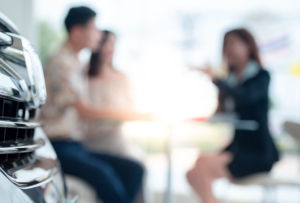 Two potential buyers discussing a car purchase with an agent near Anderson, Indiana
