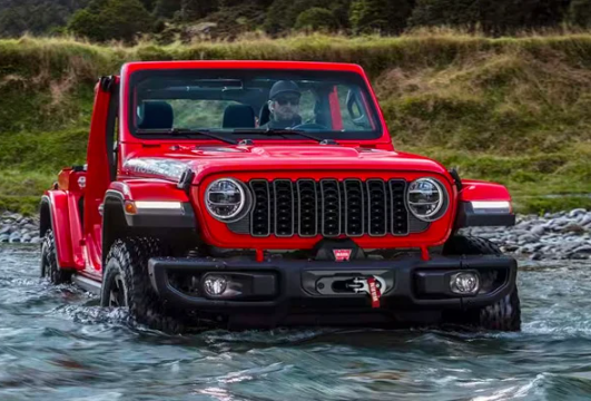 A red 2024 Jeep Wrangler driving through water near Anderson, Indiana