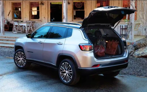 A silver 2024 Jeep Compass parked in front of a house, with it's back trunk open near Anderson, Indiana