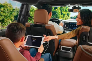 A family inside of a 2024 Chrysler Pacifica driving down a sunny street near Anderson, Indiana