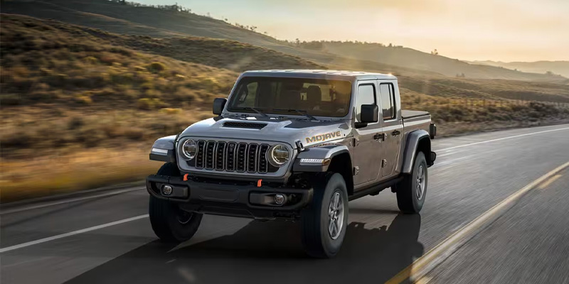 2025 Jeep Gladiator driving on a highway with desert landscape in the background Anderson, IN 